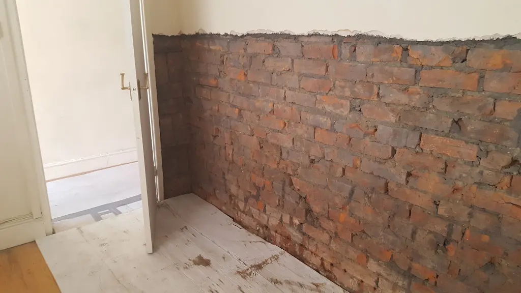 Hallway wall stripped back to brick during damp proofing works