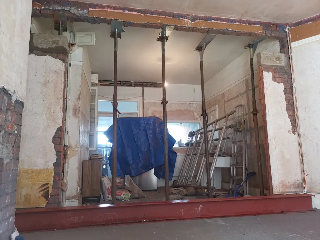 An internal opening during works, with temporary props in place and a steel beam at floor level.