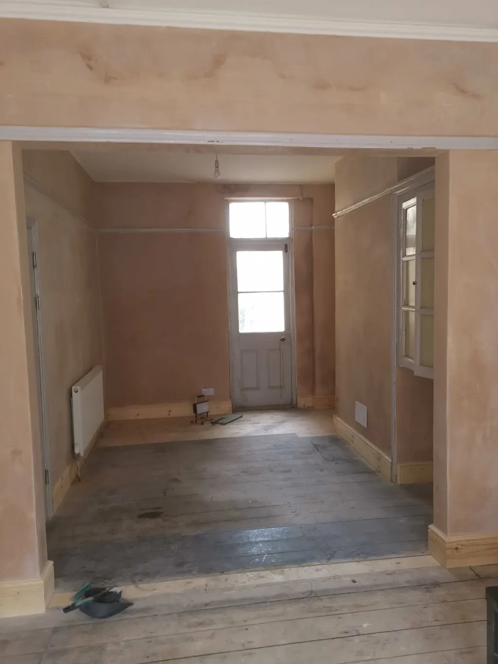 Replastered walls and an internal opening with skirting in place; floors and decoration remain unfinished.