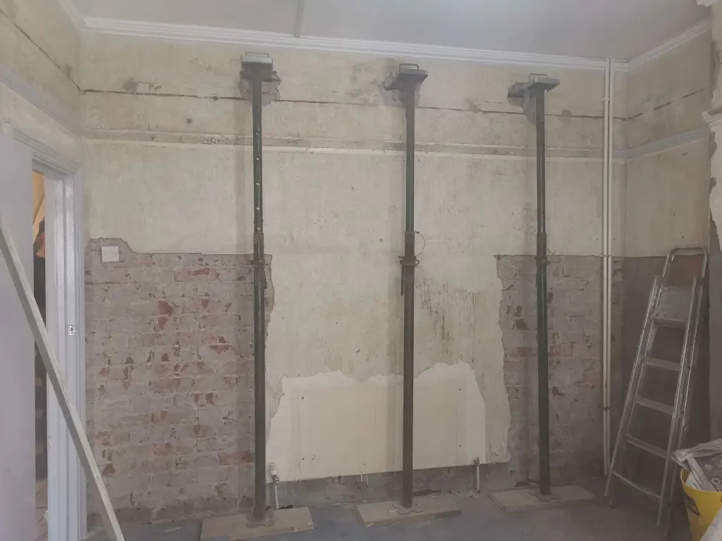 Temporary props positioned against an internal wall during renovation preparation.