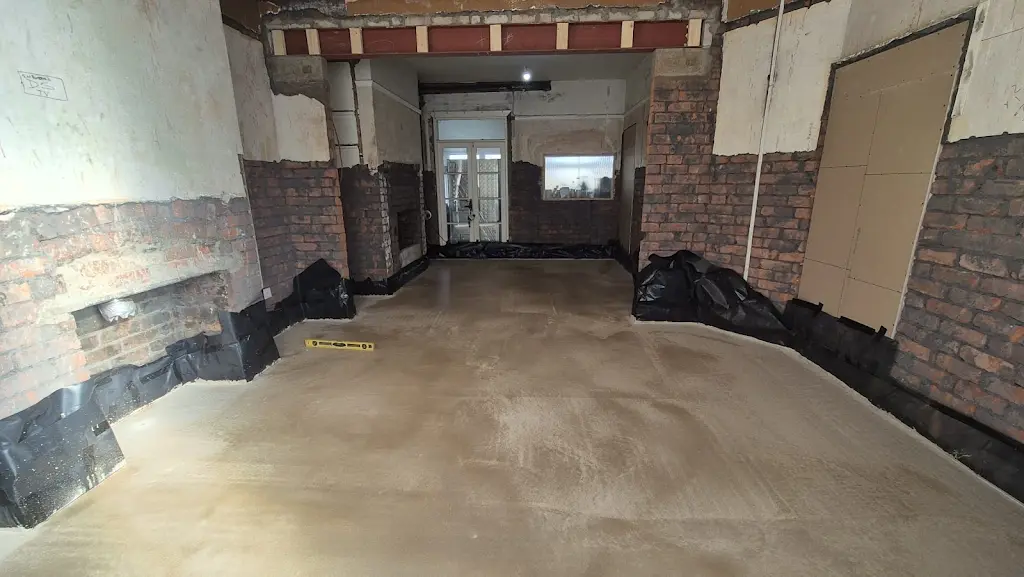 Newly laid floor across connected rooms with a yellow spirit level