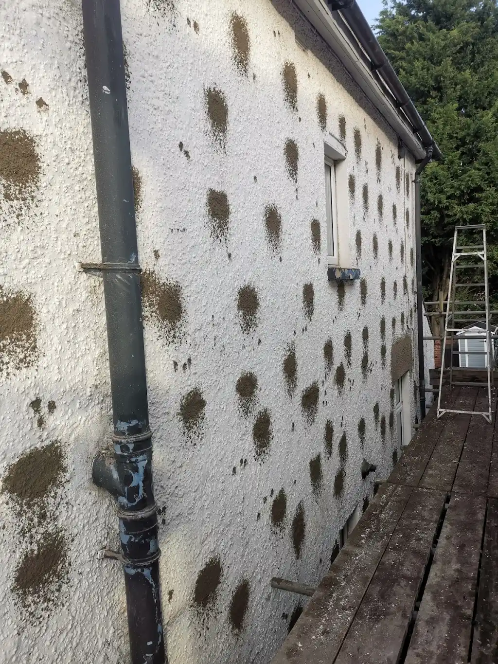 Side elevation with cavity wall-tie replacement repairs in render