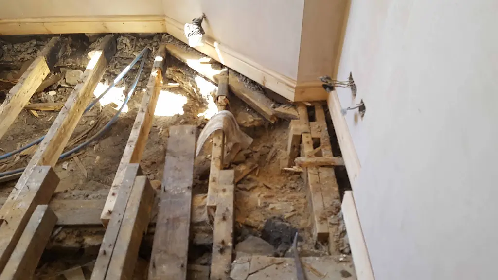 Exposed sub-floor joists during woodworm treatment preparation